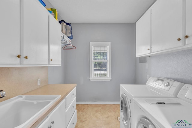 clothes washing area featuring cabinet space, baseboards, a sink, and independent washer and dryer