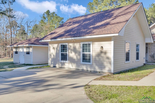 view of home's exterior featuring a shingled roof and driveway