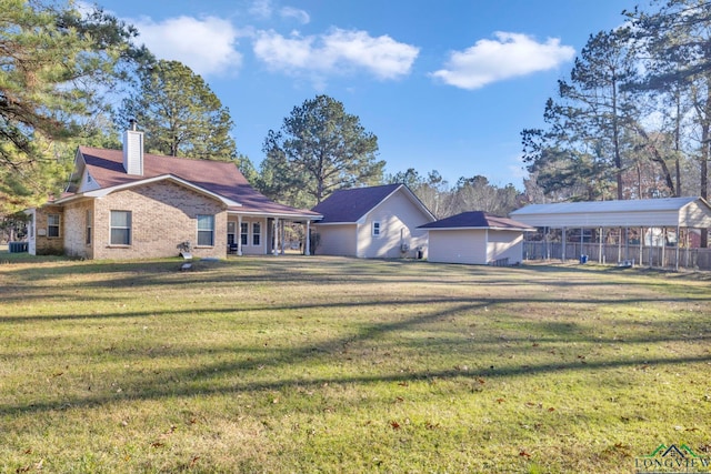 view of front facade with brick siding, a chimney, and a front lawn