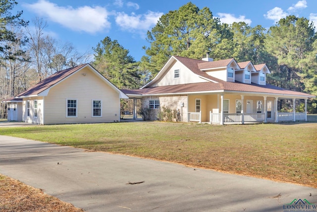 farmhouse-style home featuring a porch, a front lawn, and a chimney