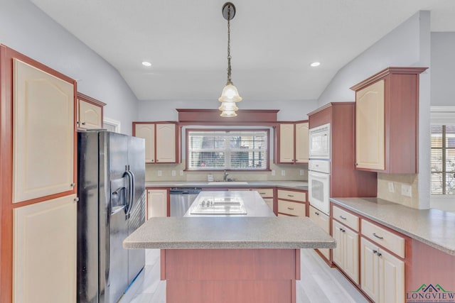 kitchen featuring tasteful backsplash, a center island, white appliances, and light countertops