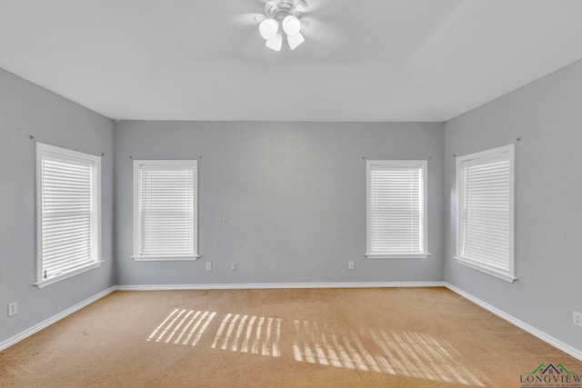 unfurnished room with carpet flooring, a ceiling fan, and baseboards