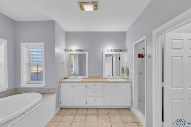 bathroom with a tile shower, tile patterned flooring, a sink, and a garden tub