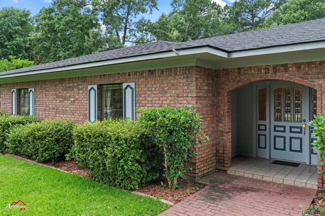 825 University Dr, Carthage, TX 75633 - property entrance featuring brick siding and a shingled roof