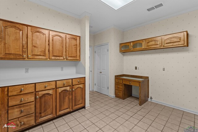 825 University Dr, Carthage, TX 75633 - kitchen featuring ornamental molding, brown cabinets, light countertops, wallpapered walls, and a desk