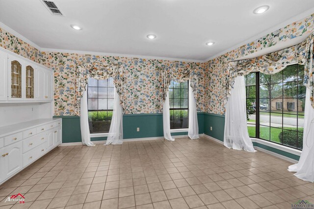 825 University Dr, Carthage, TX 75633 - unfurnished room with crown molding, plenty of natural light, wallpapered walls, baseboards, and a wainscoted wall