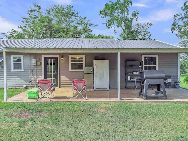 3738 Fm 161 S, Hughes Springs, TX 75656 - rear view of house with a metal roof, a patio area, and a yard