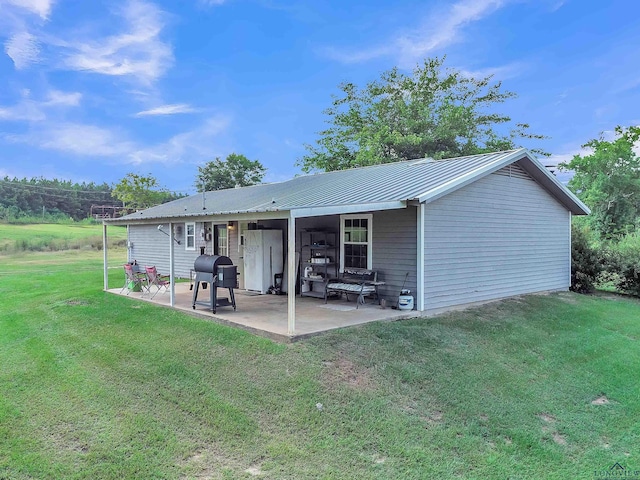3738 Fm 161 S, Hughes Springs, TX 75656 - rear view of property featuring a patio area, a lawn, and a metal roof