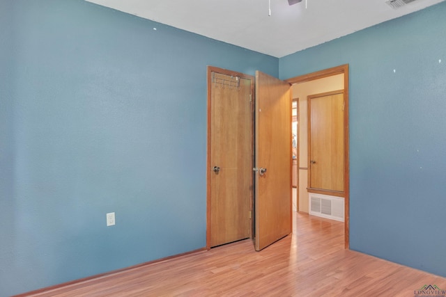 3738 Fm 161 S, Hughes Springs, TX 75656 - unfurnished bedroom featuring light wood finished floors, a closet, and ceiling fan