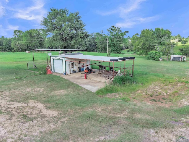 3738 Fm 161 S, Hughes Springs, TX 75656 - view of grassy yard with an outdoor structure, a garage, and view of wooded area