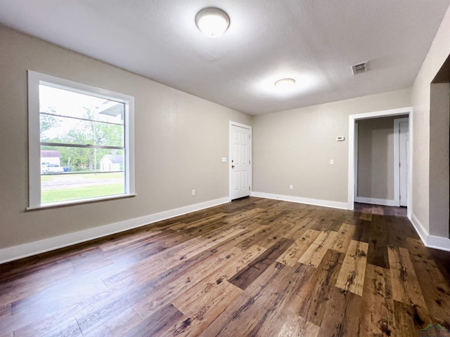 unfurnished room with dark hardwood / wood-style flooring