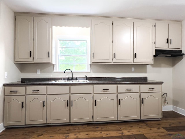 kitchen with dark hardwood / wood-style flooring, sink, and white cabinets