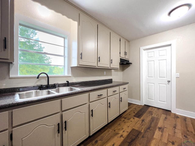 kitchen featuring dark hardwood / wood-style floors, white cabinetry, and sink