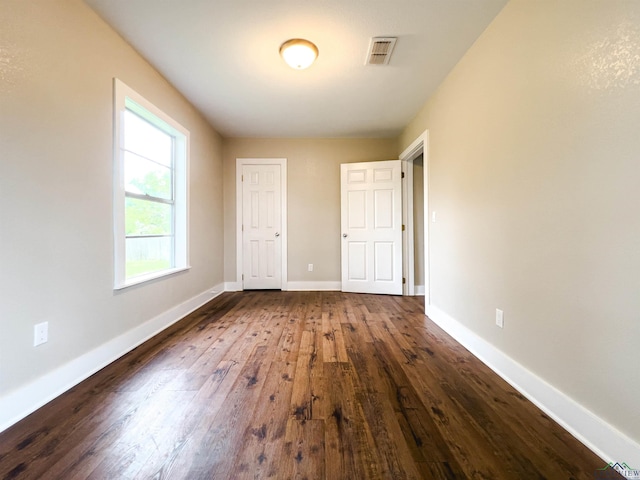 unfurnished bedroom with dark wood-type flooring