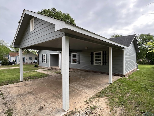 rear view of property featuring a yard and a carport