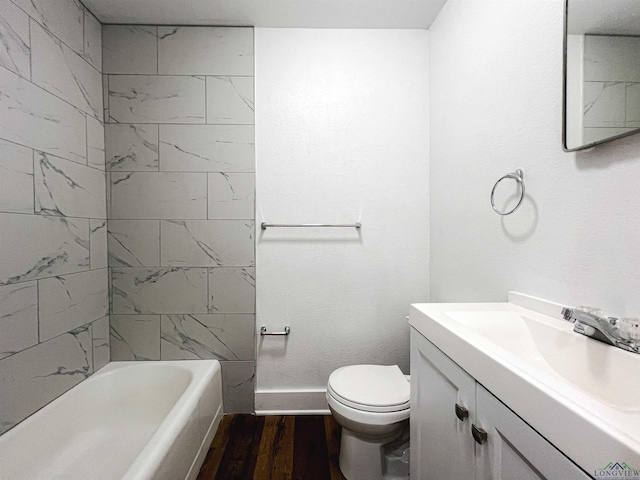 full bathroom featuring hardwood / wood-style flooring, vanity, tiled shower / bath combo, and toilet