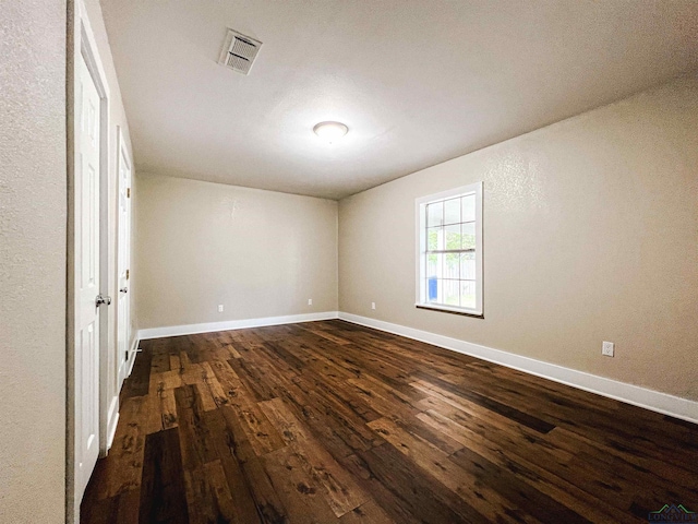 spare room with dark wood-type flooring