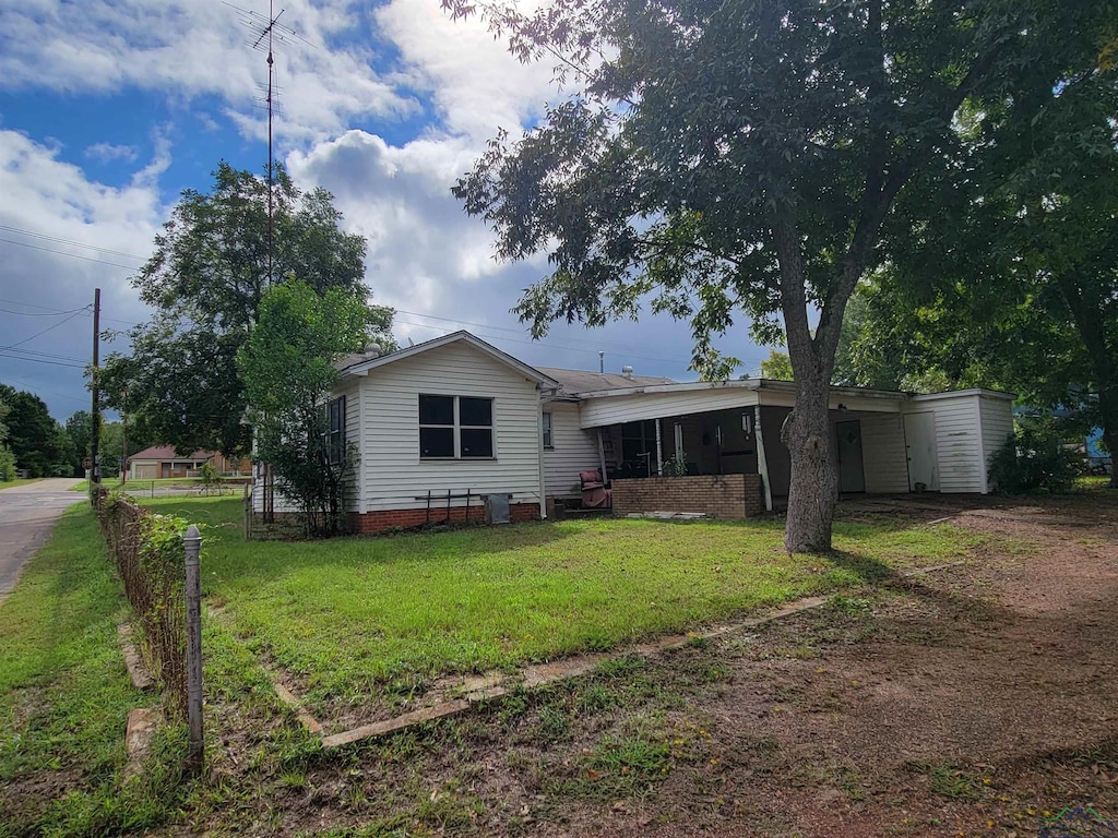 view of front of house with a carport and a front lawn