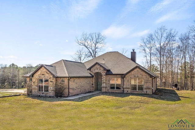 french country inspired facade featuring a front lawn