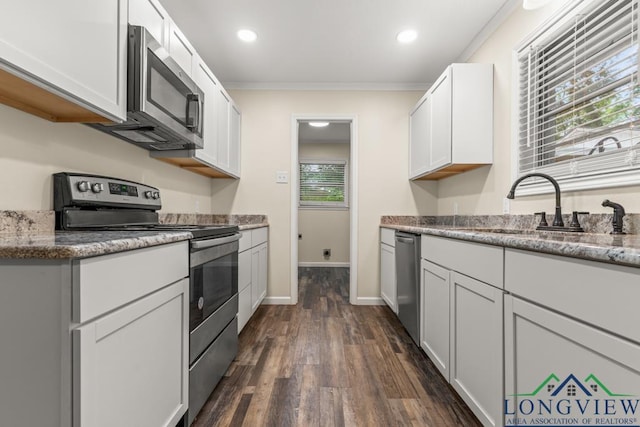 11562 19th Ave, Tyler, TX 75709 - kitchen with stainless steel appliances, dark wood-style floors, a sink, crown molding, and white cabinets