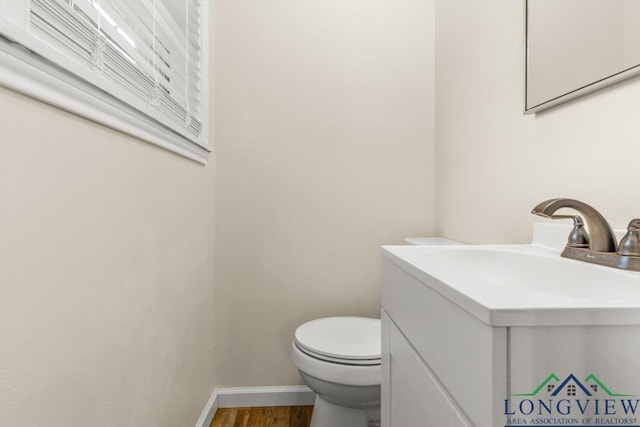 11562 19th Ave, Tyler, TX 75709 - half bathroom with vanity, wood finished floors, baseboards, and toilet