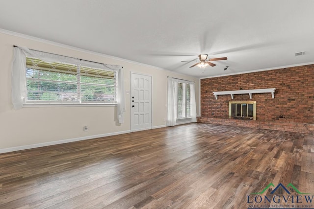 11562 19th Ave, Tyler, TX 75709 - unfurnished living room with a ceiling fan, wood finished floors, a brick fireplace, ornamental molding, and baseboards