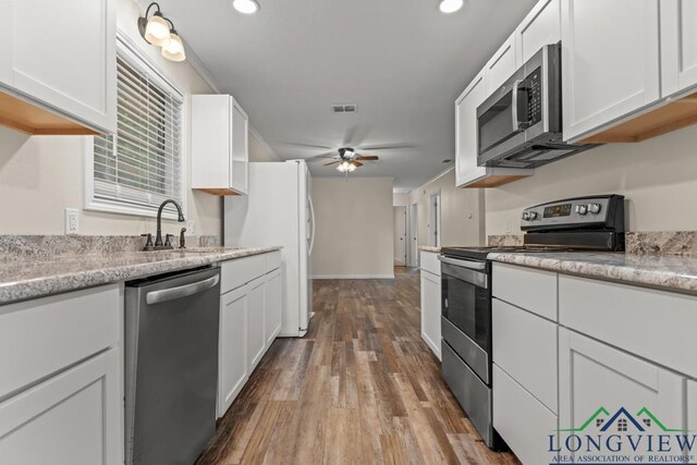 11562 19th Ave, Tyler, TX 75709 - kitchen with stainless steel appliances, a ceiling fan, a sink, white cabinetry, and recessed lighting