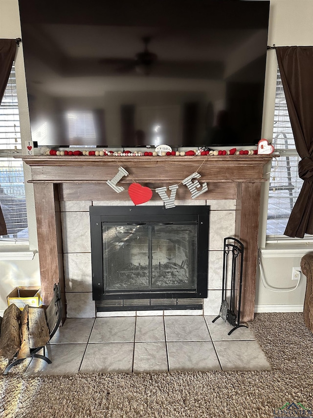 room details featuring a tiled fireplace and baseboards