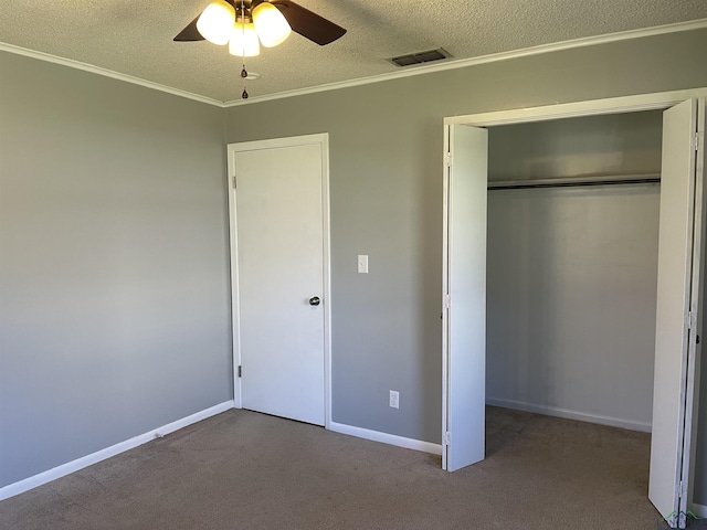 unfurnished bedroom with carpet flooring, a textured ceiling, crown molding, and visible vents