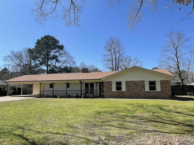 ranch-style home with brick siding, an attached carport, a chimney, and a front yard