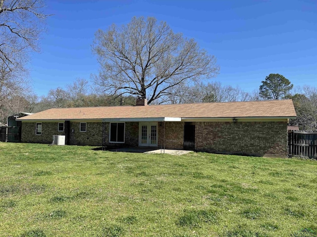 exterior space with french doors, brick siding, a front lawn, and fence