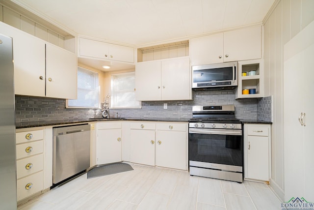 kitchen with decorative backsplash, white cabinetry, sink, and appliances with stainless steel finishes