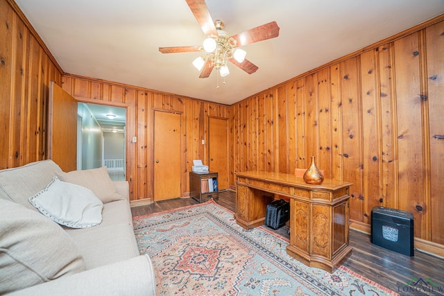 office featuring ceiling fan, dark hardwood / wood-style flooring, wooden walls, and ornamental molding