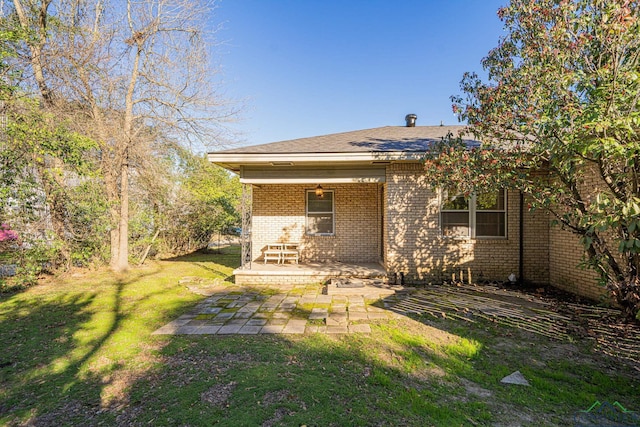 back of house with a patio area and a lawn