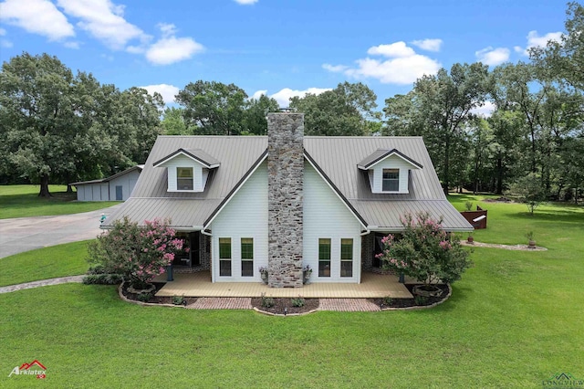 1463 County Road 106, Carthage, TX 75633 - back of house featuring a chimney, a yard, and a metal roof