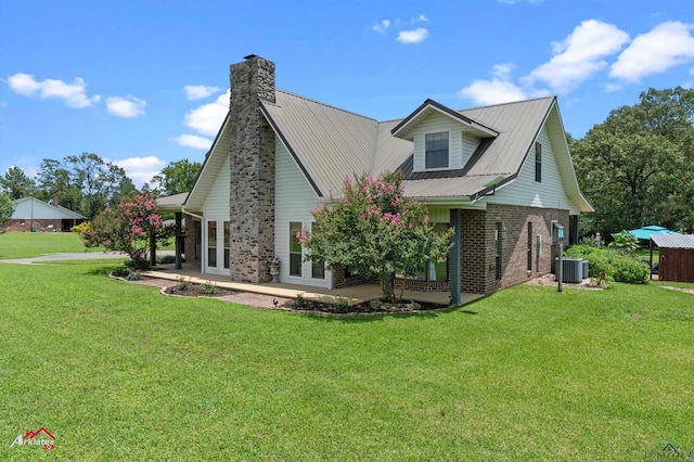 1463 County Road 106, Carthage, TX 75633 - view of home's exterior with french doors, brick siding, a yard, and a chimney