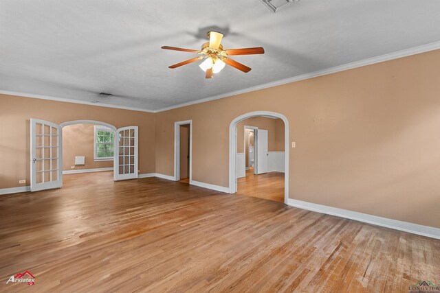 1204 Collins St, Henderson, TX 75654 - spare room with arched walkways, light wood-type flooring, ceiling fan, ornamental molding, and baseboards