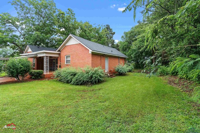 1204 Collins St, Henderson, TX 75654 - view of property exterior with brick siding and a yard