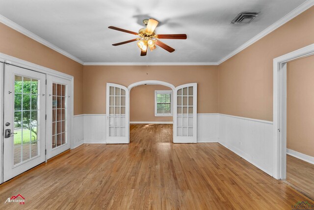 1204 Collins St, Henderson, TX 75654 - empty room with french doors, wood finished floors, a wainscoted wall, ceiling fan, and crown molding
