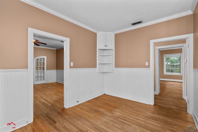 1204 Collins St, Henderson, TX 75654 - empty room featuring a wainscoted wall, light wood-style floors, and ornamental molding
