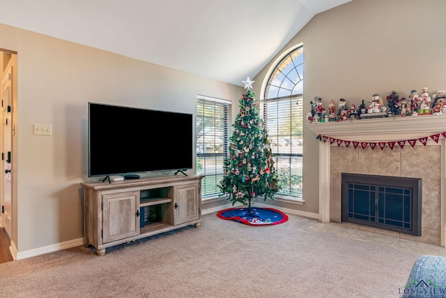 living room featuring a tile fireplace, light colored carpet, and vaulted ceiling