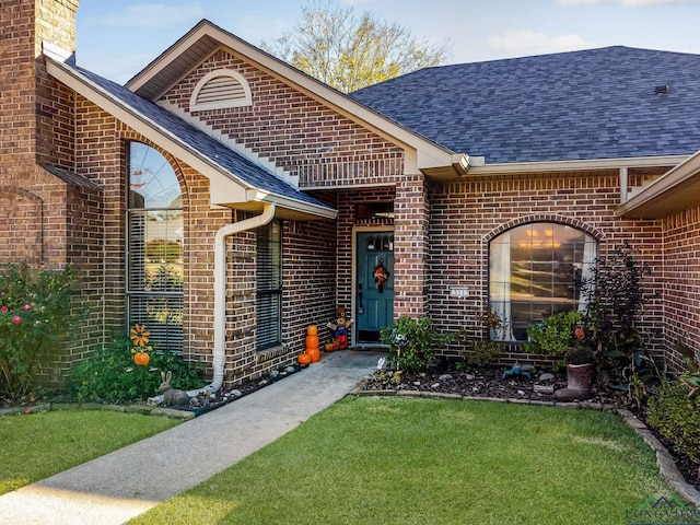 doorway to property with a lawn