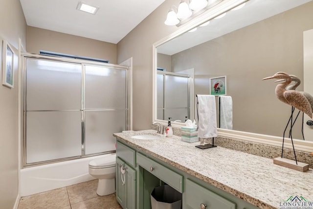 full bathroom featuring tile patterned flooring, vanity, bath / shower combo with glass door, and toilet