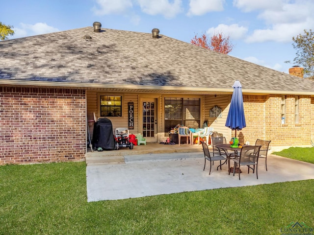 back of house with a yard and a patio