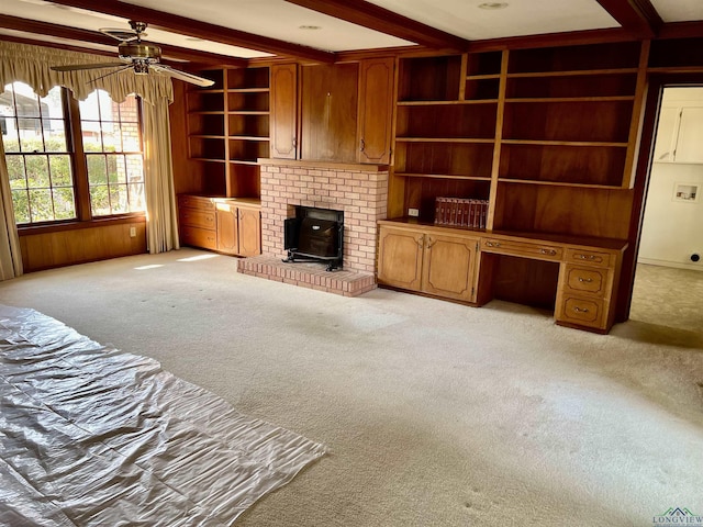 living room featuring light carpet, built in desk, beam ceiling, and built in shelves