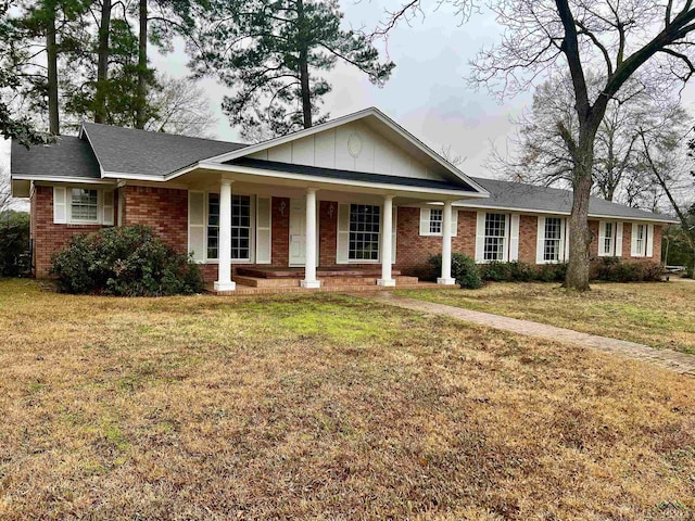 ranch-style home with a front lawn and covered porch