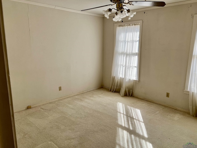 carpeted spare room featuring crown molding, ceiling fan, and a healthy amount of sunlight