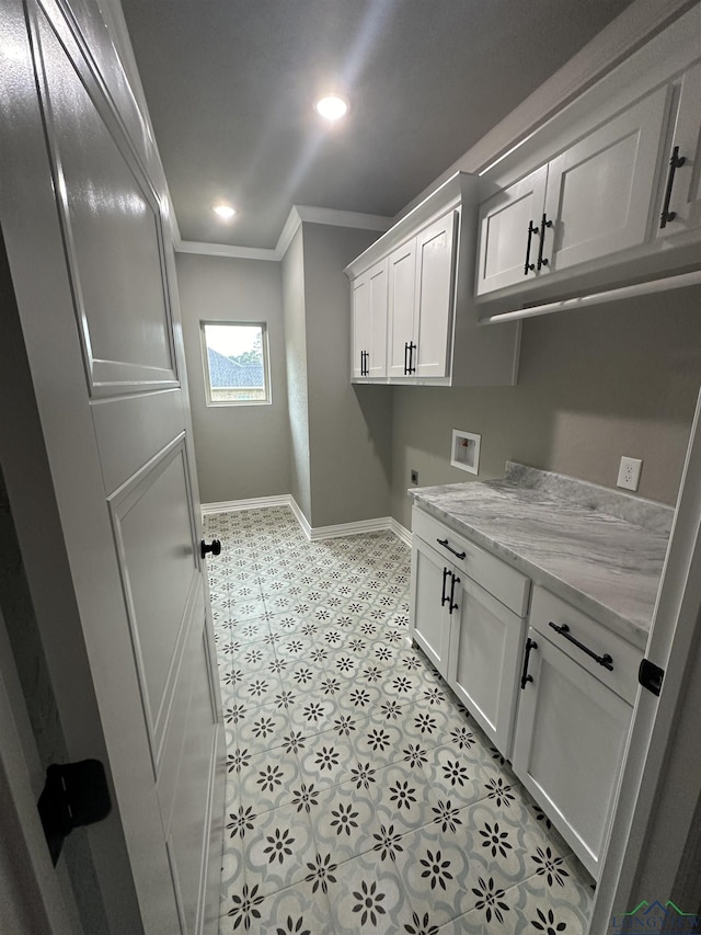 washroom with cabinets, washer hookup, and crown molding