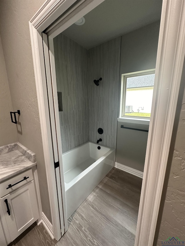 bathroom with bathing tub / shower combination, hardwood / wood-style floors, and vanity