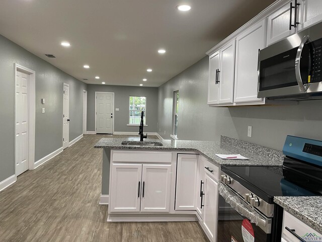 220 Myrle Ave, Longview, TX 75602 - kitchen with appliances with stainless steel finishes, a peninsula, recessed lighting, white cabinets, and light wood-style floors
